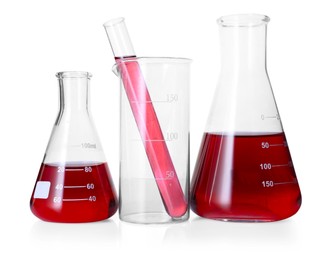 Photo of Different laboratory glassware with red liquid isolated on white