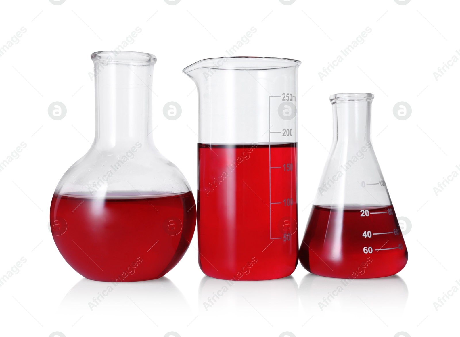 Photo of Different laboratory glassware with red liquid isolated on white