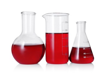 Photo of Different laboratory glassware with red liquid isolated on white