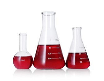 Photo of Different laboratory glassware with red liquid isolated on white