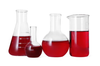 Photo of Different laboratory glassware with red liquid isolated on white