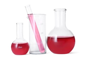 Photo of Different laboratory glassware with red liquid isolated on white