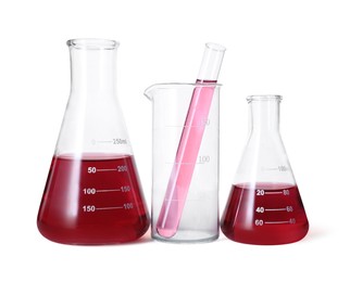 Photo of Different laboratory glassware with red liquid isolated on white