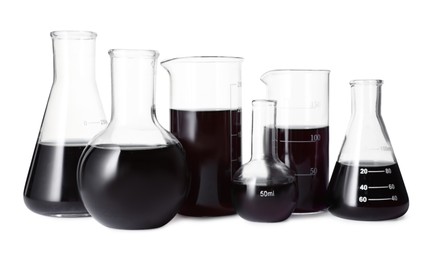 Photo of Different laboratory glassware with black liquid isolated on white