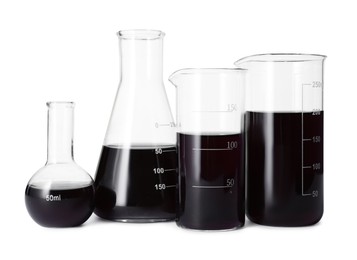 Photo of Different laboratory glassware with black liquid isolated on white