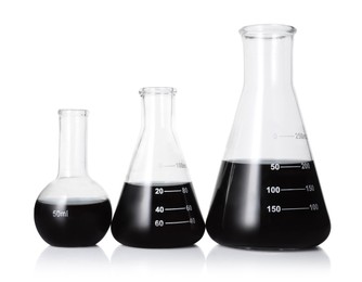 Photo of Different laboratory glassware with black liquid isolated on white