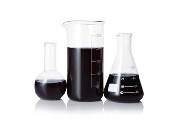 Photo of Different laboratory glassware with black liquid isolated on white