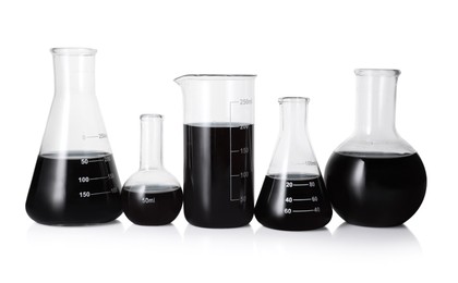 Photo of Different laboratory glassware with black liquid isolated on white