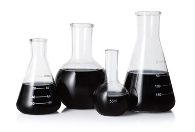 Photo of Different laboratory glassware with black liquid isolated on white