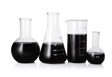 Photo of Different laboratory glassware with black liquid isolated on white