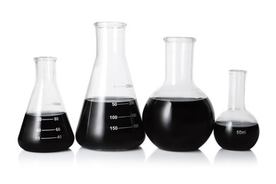 Photo of Different laboratory glassware with black liquid isolated on white