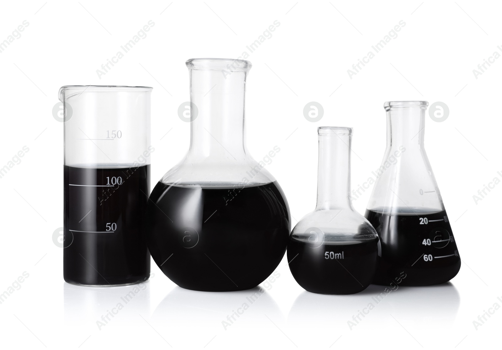 Photo of Different laboratory glassware with black liquid isolated on white