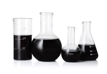 Photo of Different laboratory glassware with black liquid isolated on white