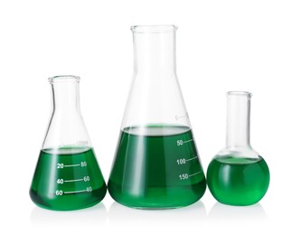 Photo of Different laboratory glassware with green liquid isolated on white