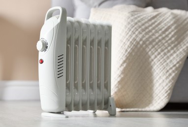 Photo of Electric heater on floor indoors, closeup. Space for text