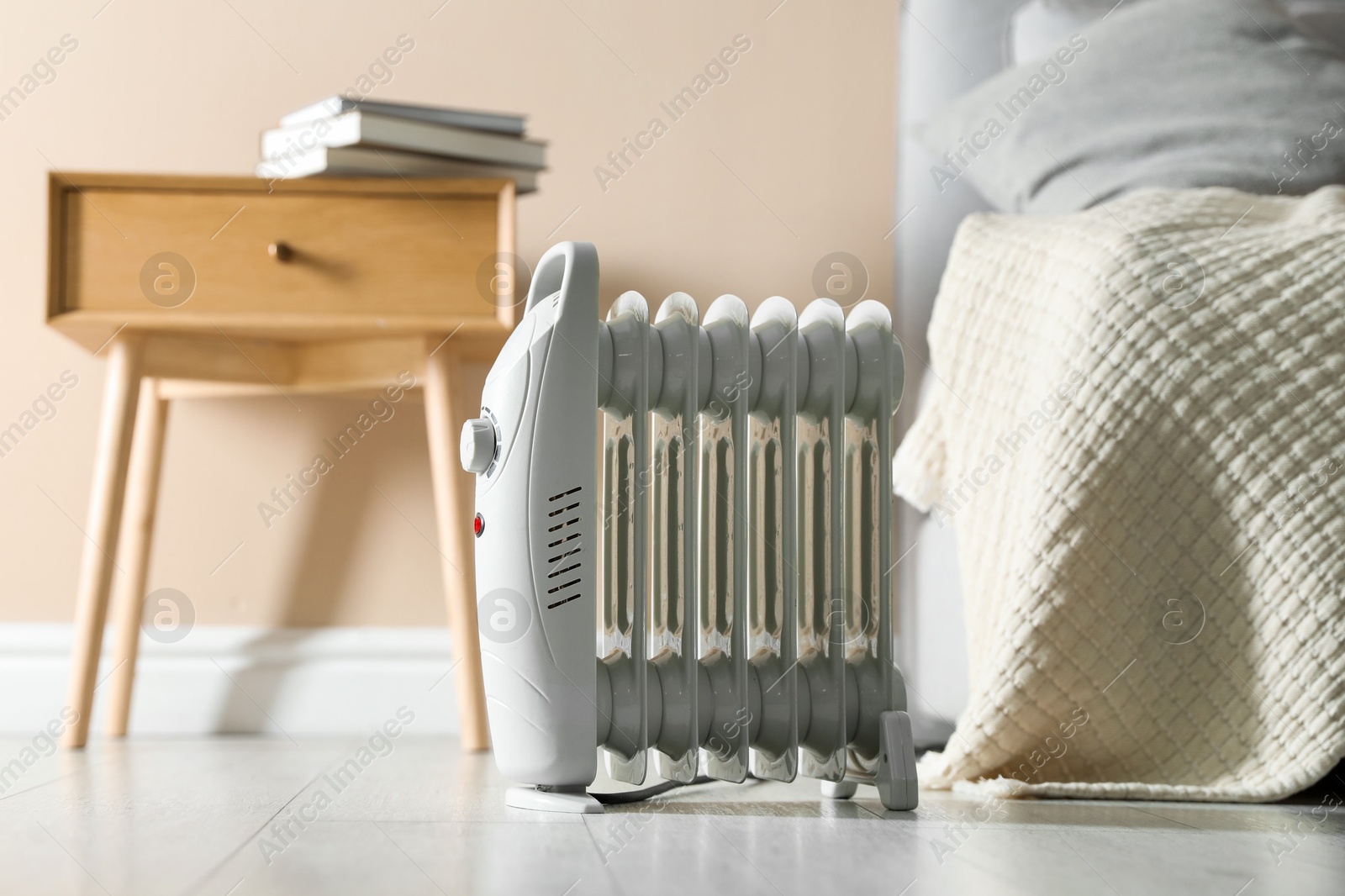 Photo of Electric heater on light wooden floor indoors