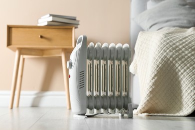 Photo of Electric heater on light wooden floor indoors