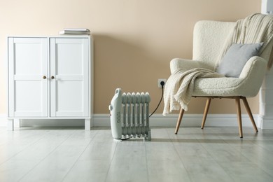 Photo of Electric heater on light wooden floor indoors
