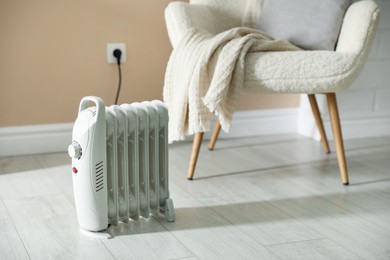 Photo of Electric heater on light wooden floor indoors