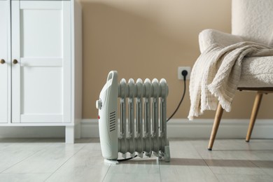 Photo of Electric heater on light wooden floor indoors