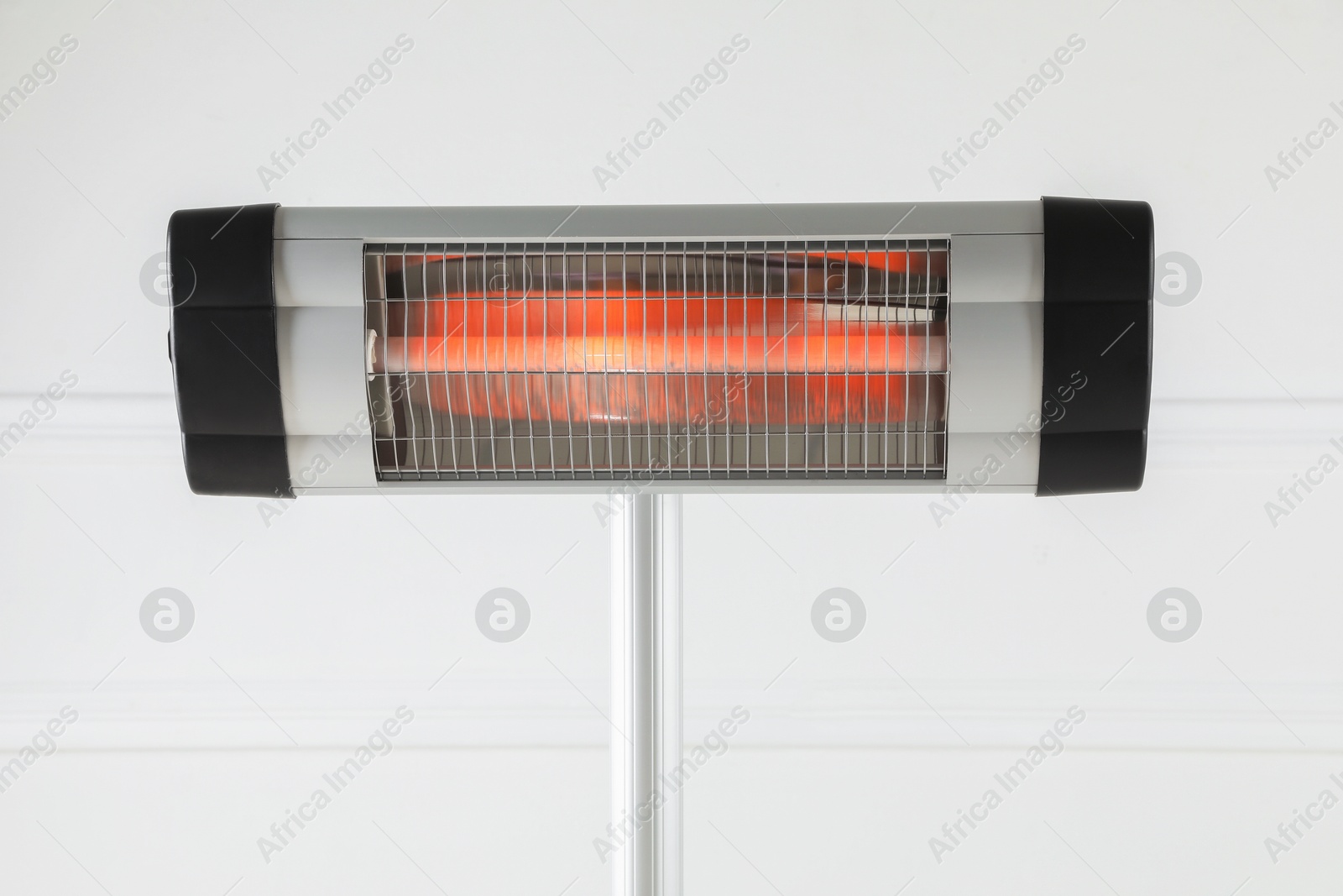 Photo of Electric infrared heater near white wall indoors, closeup
