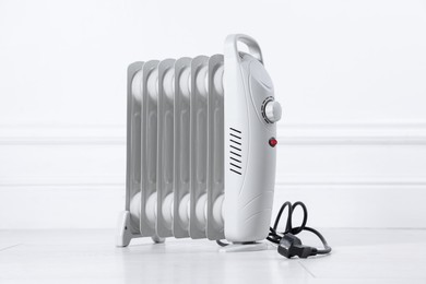 Photo of Electric heater on floor near light wall indoors