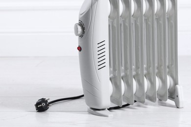 Photo of Electric heater on floor near light wall indoors. Space for text
