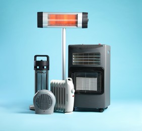 Photo of Different electric heaters on light blue background
