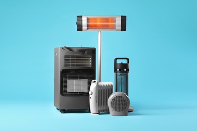 Photo of Different electric heaters on light blue background