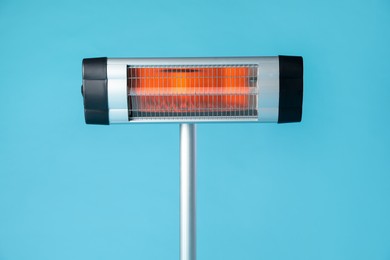 Photo of Electric infrared heater on light blue background