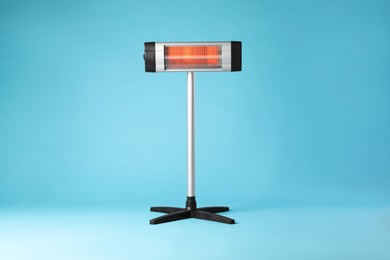 Photo of Electric infrared heater on light blue background