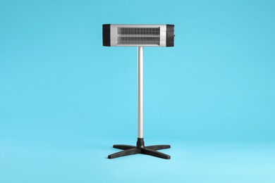 Photo of Electric infrared heater on light blue background