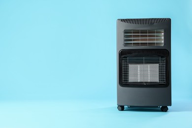 Photo of Electric heater on light blue background. Space for text