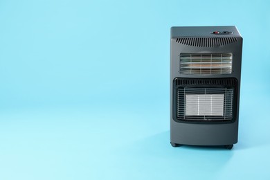 Photo of Electric heater on light blue background. Space for text