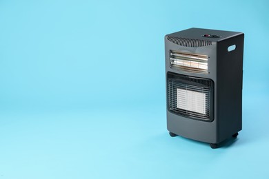Photo of Electric heater on light blue background. Space for text