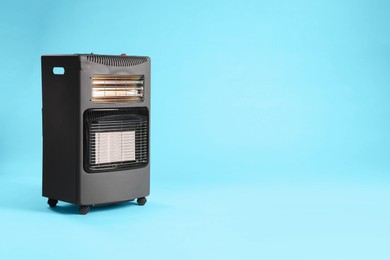 Photo of Electric heater on light blue background. Space for text