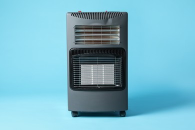 Photo of One electric heater on light blue background