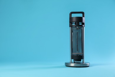 Photo of Electric heater on light blue background. Space for text