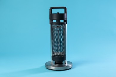 Photo of One electric heater on light blue background