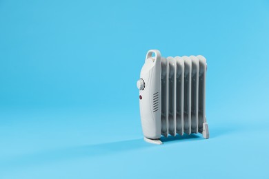 Photo of Electric heater on light blue background. Space for text