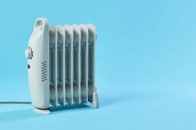 Photo of Electric heater on light blue background. Space for text