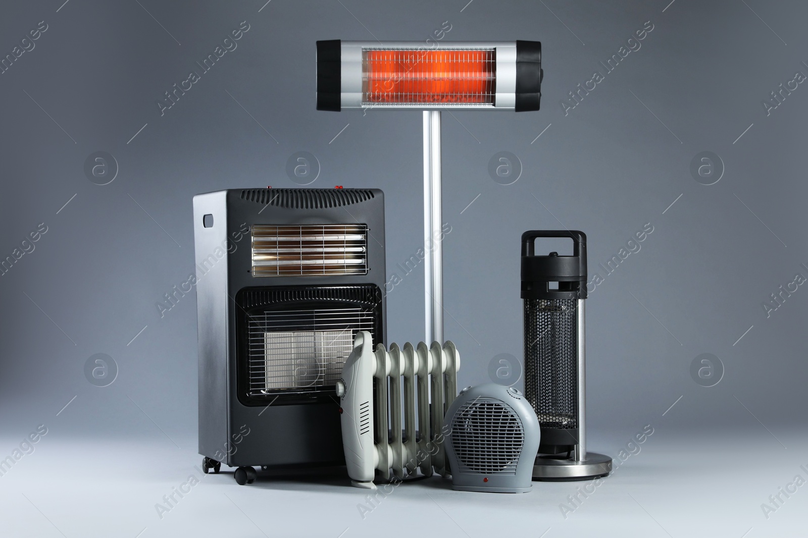 Photo of Different types of electric heaters on grey background