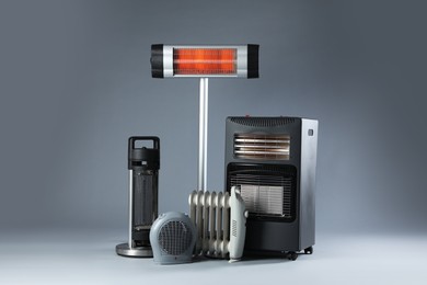 Photo of Different types of electric heaters on grey background