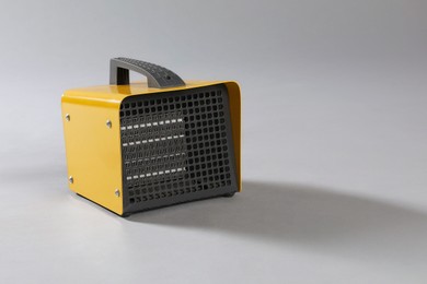Photo of One electric fan heater on grey background. Space for text