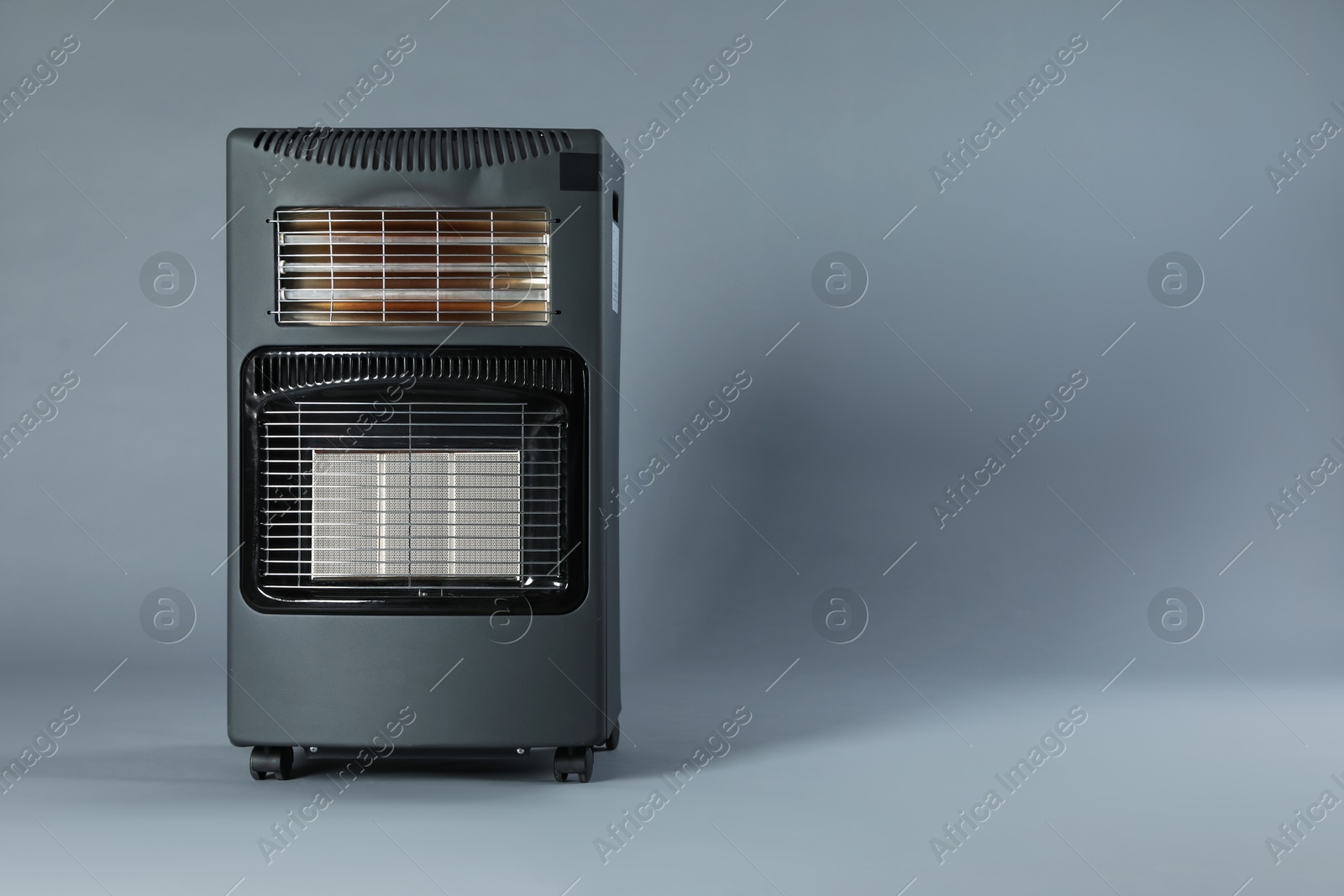 Photo of One electric heater on grey background. Space for text