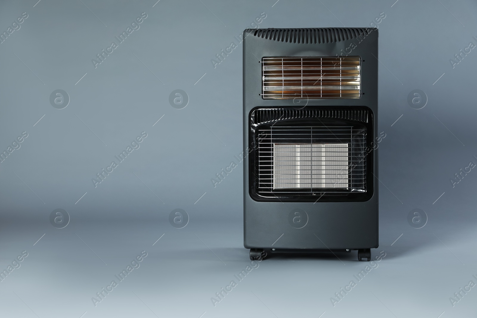 Photo of One electric heater on grey background. Space for text