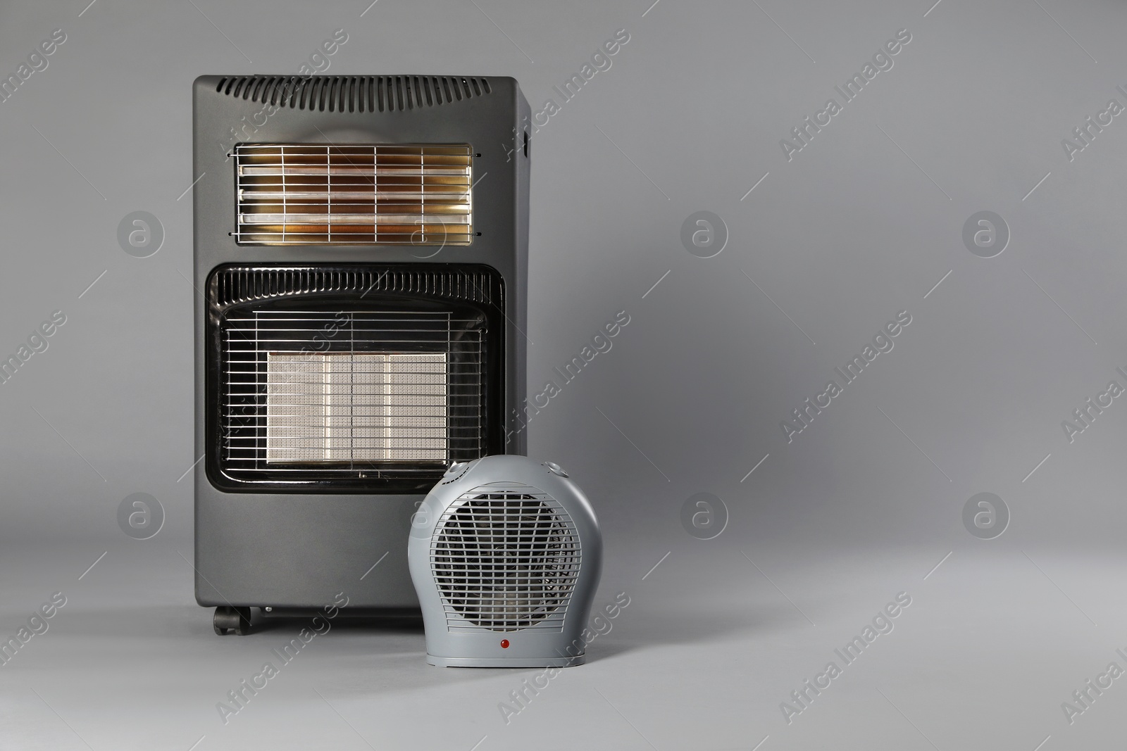 Photo of Different types of electric heaters on grey background. Space for text