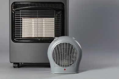 Photo of Different types of electric heaters on grey background, closeup. Space for text