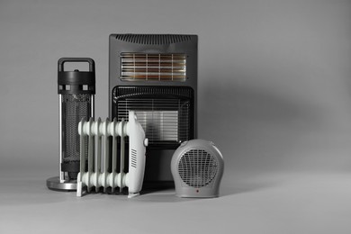 Photo of Different electric heaters on grey background. Space for text