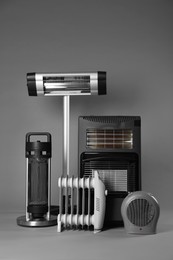 Photo of Different types of electric heaters on grey background